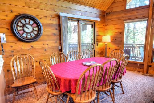 a dining room with a table and chairs and a clock at Treetops Cabin in Yosemite West