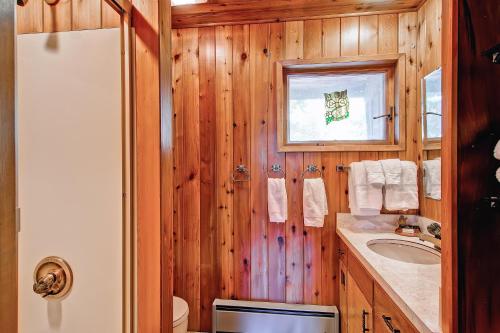 baño con paredes de madera, lavabo y espejo en Stoneoaks en Yosemite West