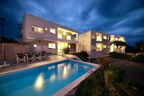 a house with a swimming pool in front of a house at Crystal Villa Imgya in Miyako-jima