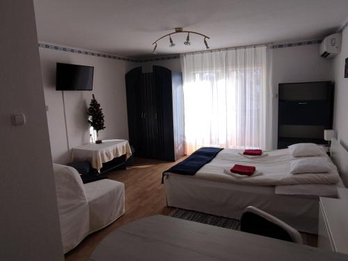 "ハルカーニャ"にあるHarkányi Ragyogó Apartmanのベッド2台とリビングルームが備わるホテルルームです。