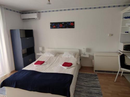 "ハルカーニャ"にあるHarkányi Ragyogó Apartmanのベッドルーム1室(赤い枕2つ付)