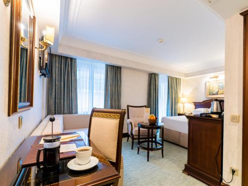 a hotel room with a desk and a bed and a table at Ilci Residence Hotel in Ankara