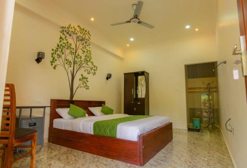 a bedroom with a bed and a tree in it at ANNUS HOMESTAY RAMAKKALMEDU in Ramakkalmedu