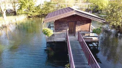 a wooden cabin on the water with a dock at Ferienwohnung Dornau in Langkampfen
