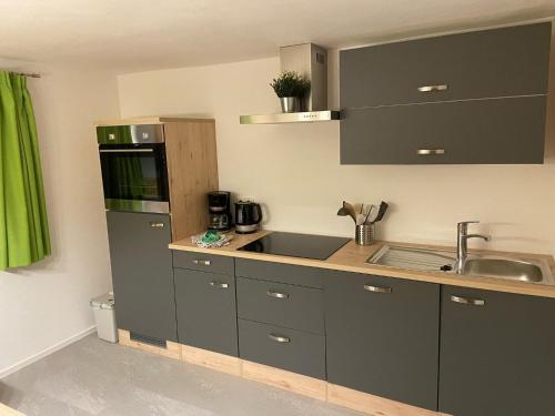 a kitchen with gray cabinets and a sink at Ferienwohnung Dornau in Langkampfen