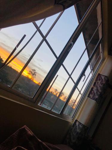 a window in a room with a view of the sunset at Keshiya Holiday Home in Nuwara Eliya