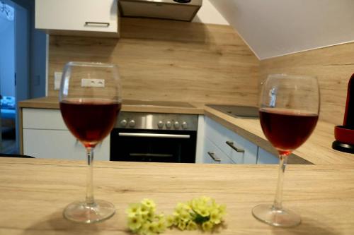 two glasses of wine sitting on a counter in a kitchen at Ferienwohnungen ARIKOGEL Bad Goisern in Bad Goisern