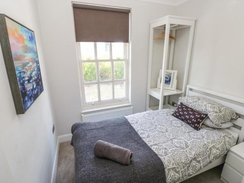 a bedroom with a bed and a window at Crown Cottage in Tenby