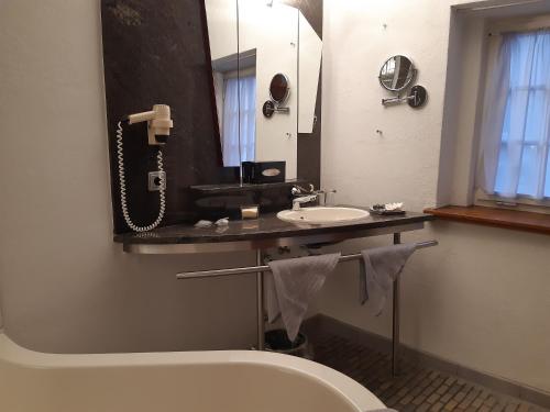 a bathroom with a sink and a toilet and a mirror at Schiefes Haus in Ulm