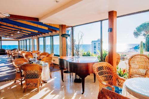 a restaurant with tables and chairs and a view of the ocean at Hotel Roger de Flor by Seleqtta in Lloret de Mar