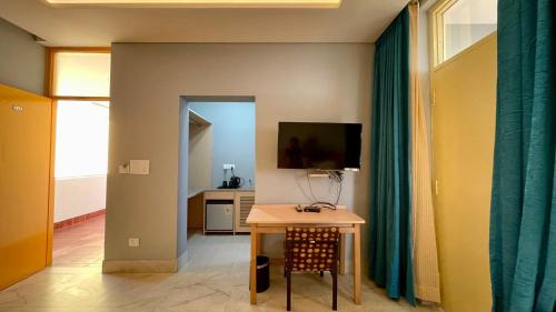 a living room with a table and a television at Madpackers Bir in Bīr