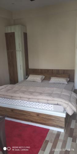 a bedroom with a large bed with a wooden frame at Saanidhya Sunset View Villa in Mukteswar