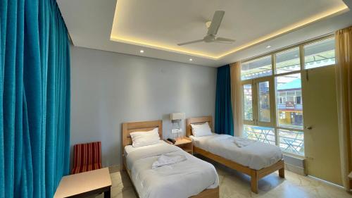 a room with two beds and a window at Madpackers Bir in Bīr