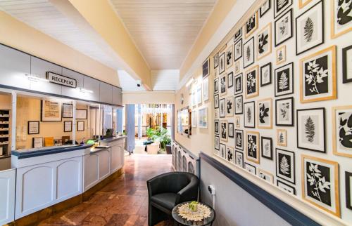 a hallway with black and white pictures on the wall at Hotel Jogar in Balatonföldvár