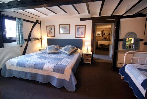 um quarto com uma cama com um edredão azul em Gîte La Grande Francorchamps Ardennaise em Stavelot