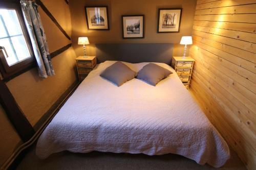 a bedroom with a large white bed with two lamps at Gîte La Grande Francorchamps Ardennaise in Stavelot