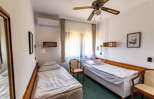 a hospital room with two beds and a mirror at Hotel Jogar in Balatonföldvár