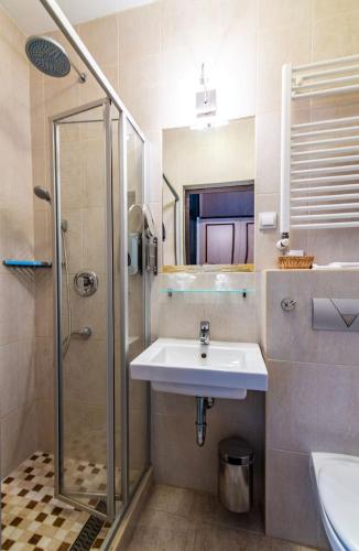 a bathroom with a sink and a shower at Hotel Jogar in Balatonföldvár