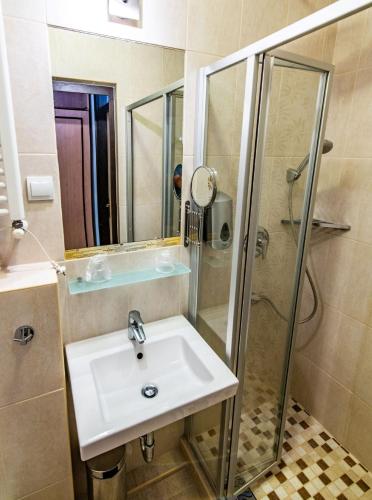 a bathroom with a sink and a shower at Hotel Jogar in Balatonföldvár