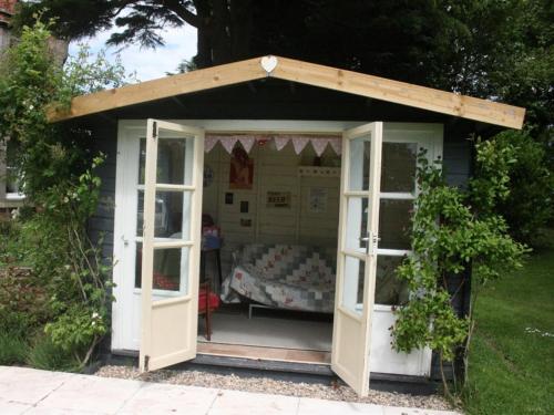 um pequeno barracão com uma cama em Broomhouse Farmhouse em Cheswick