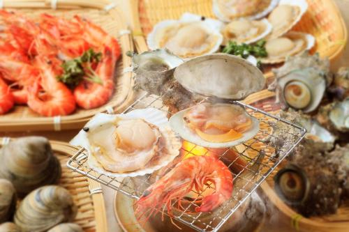 a bunch of seafood on plates on a table at Boso Shirahama Umisato Hotel in Minamiboso