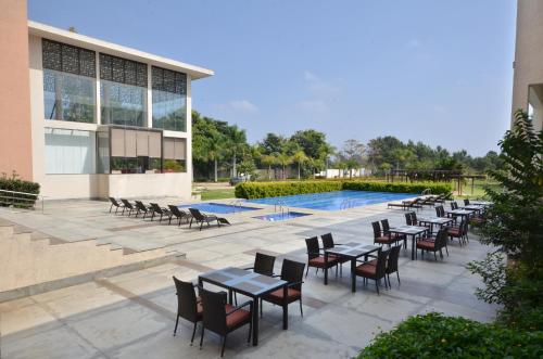a row of tables and chairs next to a pool at Spree Resort At Century Wintersun in Dod Ballāpur