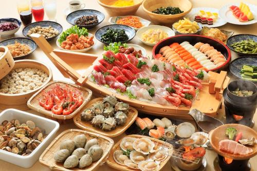 una tabella ricoperta da molti tipi di alimenti diversi di Boso Shirahama Umisato Hotel a Minamiboso