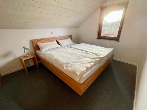 a bed in a small room with a window at Ferienhaus Rhöner Wohnen in Hilders