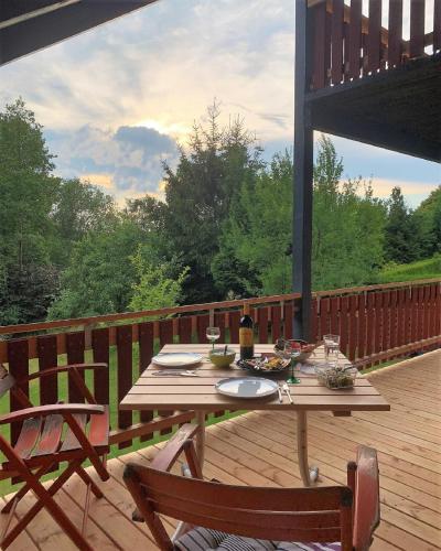 a wooden table on a deck with a meal on it at Ferienhaus Rhöner Wohnen in Hilders