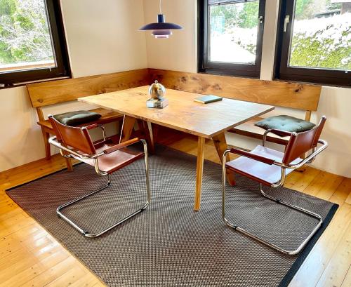 uma mesa de jantar com 2 cadeiras e uma mesa de madeira em Ferienhaus Rhöner Wohnen em Hilders