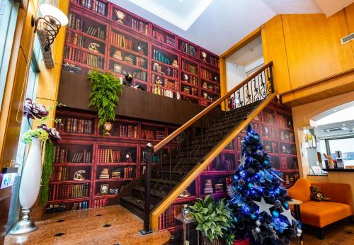 a christmas tree in a living room with a staircase at All Fun Business Hotel in Taichung