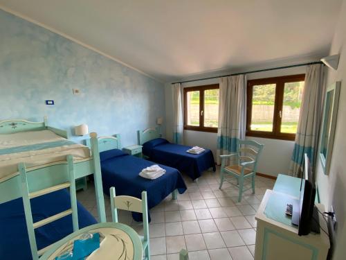 a room with two bunk beds and a table and chairs at La Locanda del Mare in Valledoria