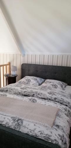 une chambre avec un lit avec une couette noire et blanche dans l'établissement La Chapelle Saint-Nicolas, à Cassel