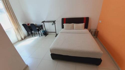 a bedroom with a bed and a table and chairs at KompoVilla in Kuantan