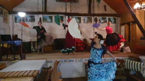 a group of people dancing on a stage with umbrellas at Kurnik Polski agroturystyka in Tykocin