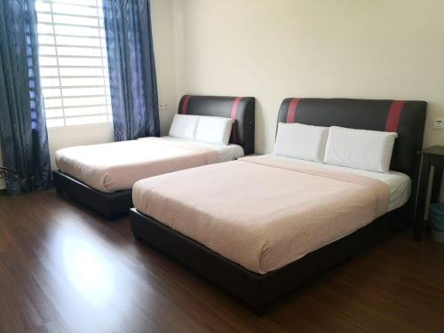 two beds sitting in a room with at KompoVilla in Kuantan