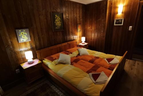 a bedroom with a large bed with two lamps at Haus Fiegl in Oetz