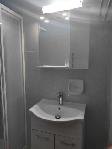 a white bathroom with a sink and a mirror at Friendly Studios in Iraion