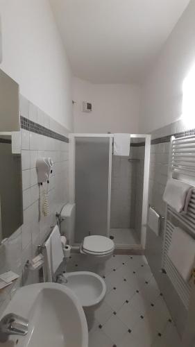 a white bathroom with a toilet and a sink at Albergo Moderno in Lucca