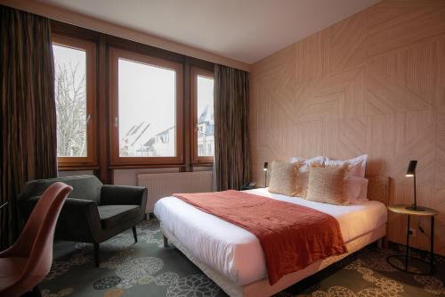 a hotel room with a bed and a chair at Hôtel Restaurant Vaillant proche Europapark Rulantica in Sélestat