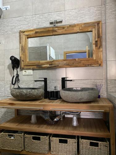 a bathroom with two sinks and a mirror at Complejo Rural Rincón del Paraíso in Valencia del Mombuey