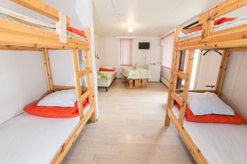 a room with three bunk beds and a table at Tampere Camping Härmälä in Tampere