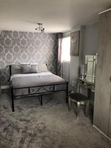 a bedroom with a bed and a table and a chair at Wesley Rooms Annexe in Ironbridge