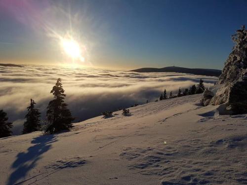 a view from the top of a snowy mountain with clouds at Velký apartmán Sophia (s infrasaunou) č. 1 in Velké Losiny