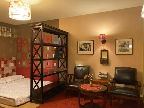 a bedroom with a bed and a desk and chairs at MuziKafe - Home of Culture in Ptuj