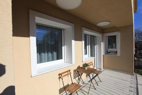 two chairs on a porch with two windows at Paskal-Lux Apartments with Free Parking and AC in Budapest