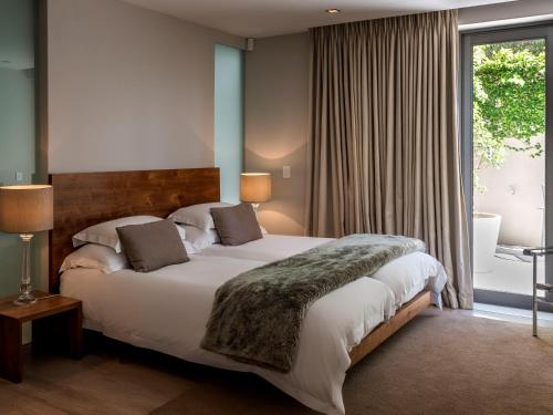 a bedroom with a large bed and a large window at Blue Views Villas and Apartments in Cape Town