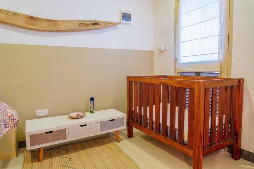 a baby room with a crib and a table at Zanzibar Tiny Villa at La Villa De Victor in Matemwe