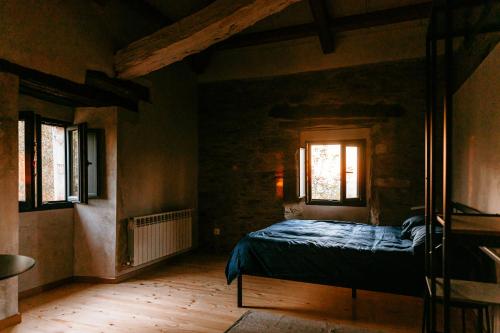1 dormitorio con 1 cama y 2 ventanas en Apartamento turístico rural Casa Chaín en Lugo