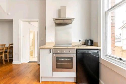 a kitchen with a stove and a sink at The Hideaway, Family apartment close to the beach. in Paignton